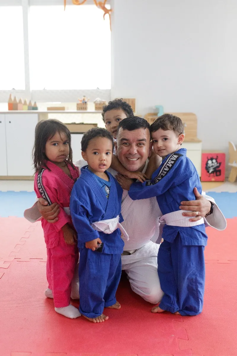 Crianças de quimono no tatame com o instrutor