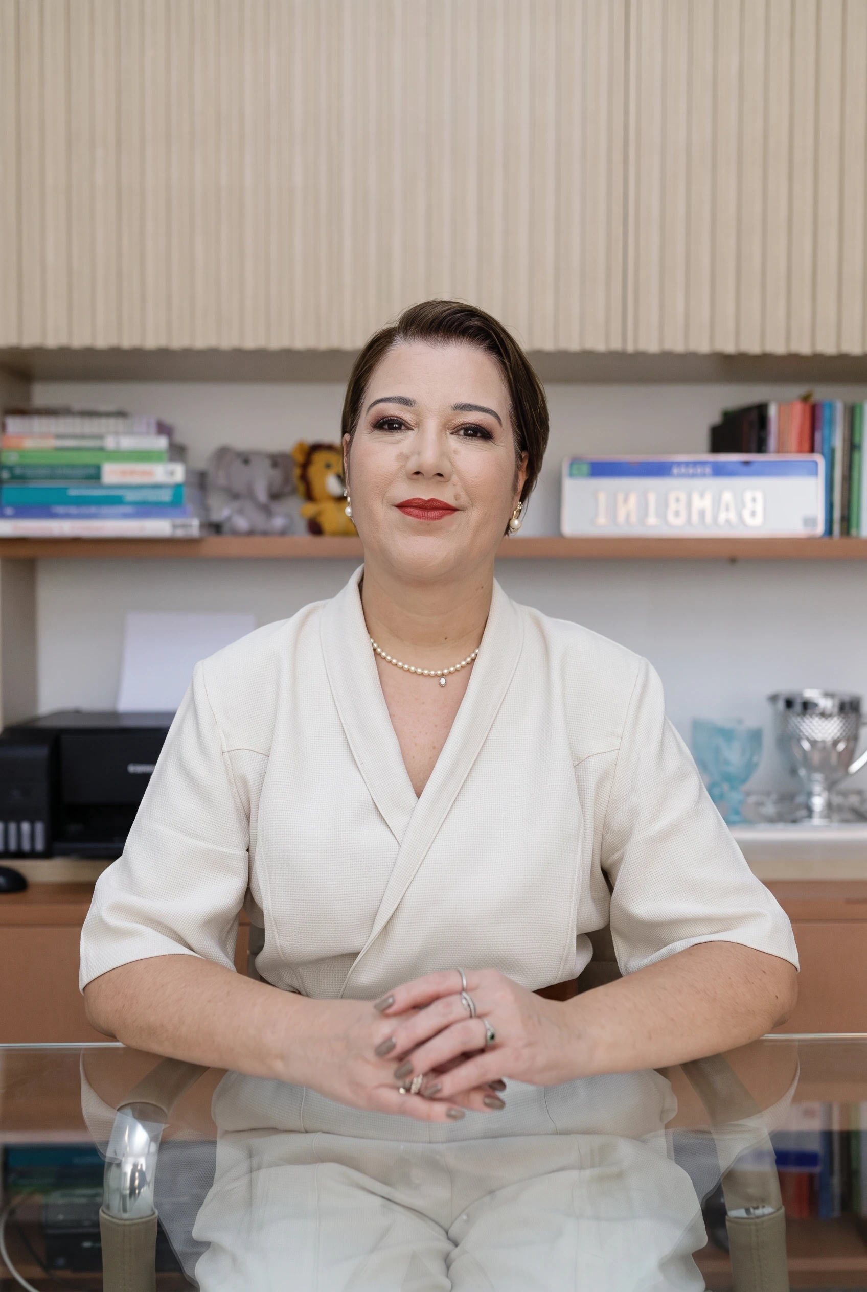 Luana, gestora da Escola Bambini, sentada à mesa da direção